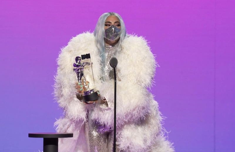 Lady Gaga, in a feathered coat and jumpsuit by Valentino, accepts the award for Artist of the Year during the 2020 MTV Video Music Awards. AFP