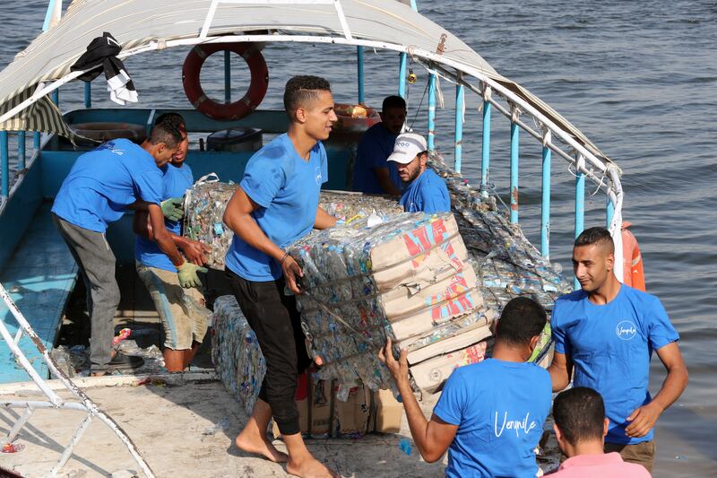 Fishermen working for the group remove plastic waste from the river.