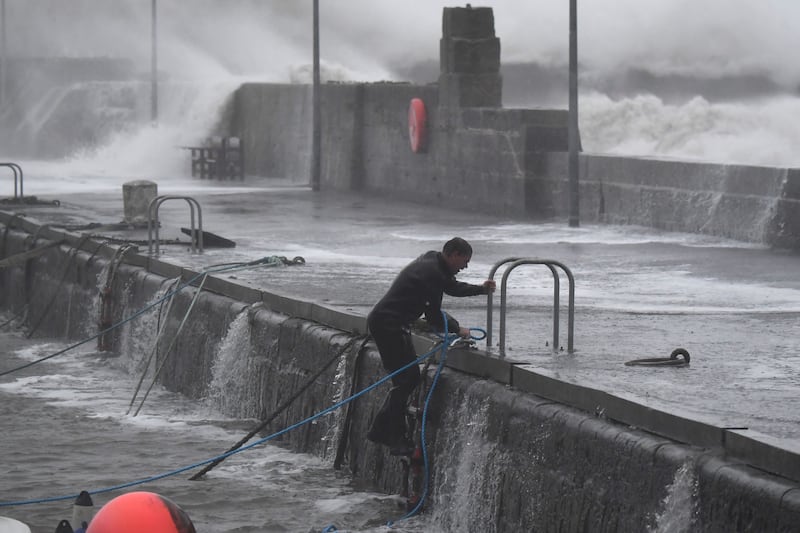 A boat owner braves Storm Babet to secure vessels at Stonehaven harbour, in north-east Scotland. AFP