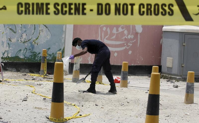 An explosives specialist police officer collects bomb samples after a blast in the village of Sitra, south of Manama, Bahrain, on July 28, 2015. Hamad I Mohammed / Reuters
