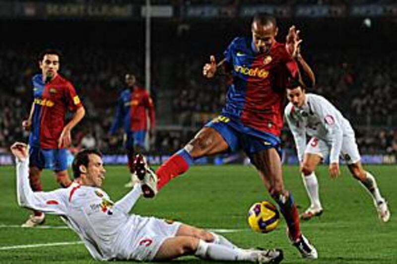 Theirry Henry, right, scorer of Barcelona's first, challenges Mallorca's Jose Miguel Gonzalez.