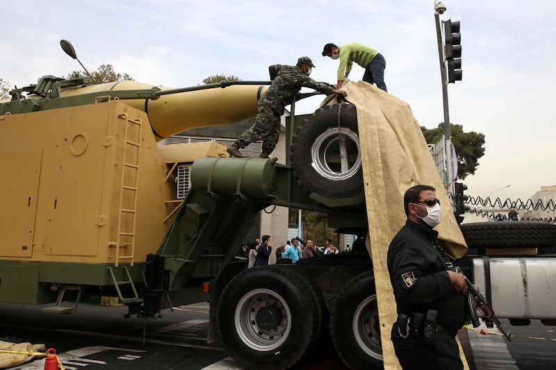 Iranian Revolutionary Guard members cover a surface-to-surface missile after it was displayed in an annual gathering in front of the former U.S. Embassy marking the anniversary of its 1979 takeover, in Tehran, Iran, Saturday, Nov. 4, 2017. Iran on Saturday displayed a surface-to-surface missile as part of events marking the anniversary of the 1979 U.S. Embassy takeover and hostage crisis amid uncertainty about its nuclear deal with world powers. (AP Photo/Vahid Salemi)