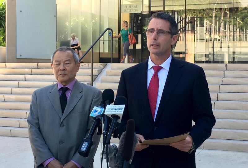 Paul Delacourt, the FBI special agent in charge of the Hawaii bureau, (R), speaks at a news conference as Acting US Attorney Elliot Enoki, (L), listens outside federal court in Honolulu on Monday. AP / Caleb Jones