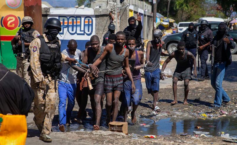 Recaptured prisoners are led by police outside Croix-des-Bouquets jail in Port-au-Prince, Haiti, after an attempted breakout. AP