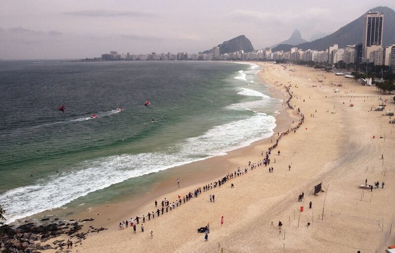 A human chain is formed on Leme beach, promoting cleaner beaches and marine environments, in Rio de Janeiro, Brazil on the World Ocean Day. AFP