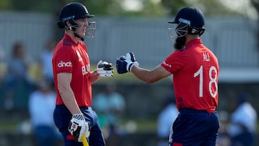 England's Harry Brook and Moeen Ali bump gloves during their partnership against Namibia at an ICC Men's T20 World Cup cricket match at Siv Vivian Richards Stadium in North Sound, Antigua and Barbuda, Saturday, June 15, 2024.  (AP Photo / Ricardo Mazalan)