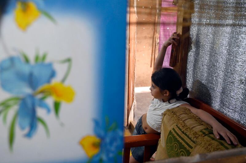 A Syrian girl sits inside a tent at a refugee camp in Akkar, Lebanon. EPA