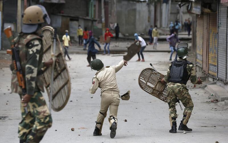 A policeman throws back a stone at Kashmiri youth during clashes in Srinagar.  Farooq Khan / EPA