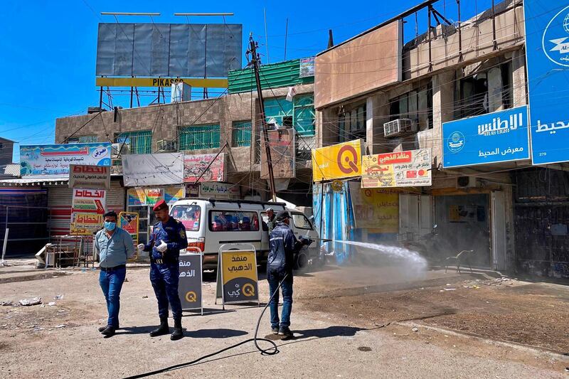 A civil defence worker sprays disinfectant as a precaution against the coronavirus in the eastern neighbourhoods of Baghdad, Iraq. AP Photo