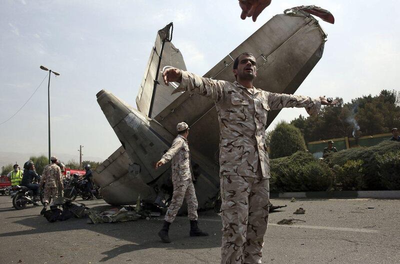 Iranian Revolutionary Guards try to prevent photographers from approaching the wreckage of a passenger plane crash near the capital Tehran on Sunday. Vahid Salemi / AP Photo