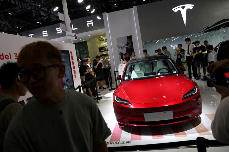 Visitors stand outside barriers surrounding Tesla's new Model 3 saloon displayed at the China International Fair for Trade in Services in Beijing last month. Reuters