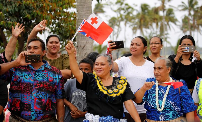 People wave as the royal motorcade carrying Meghan, Duchess of Sussex, and Britain's Prince Harry, Duke of Sussex, travels in Tonga. Reuters