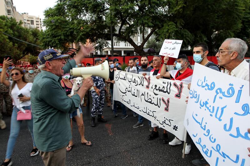 Anti-government protesters carry a banner with Arabic words reading 'No to oppression, no to military terrorism, no to the fascist regime', during a march protest from the Justice palace to the Military court opposite the French ambassador's house in Beirut, Lebanon.  EPA