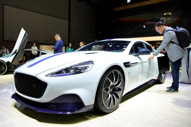 FILE PHOTO: A man touches an Aston Martin's electric vehicle(EV) Rapide E during the media day for Shanghai auto show in Shanghai, China April 16, 2019. REUTERS/Aly Song/File Photo