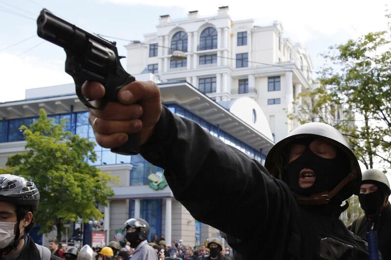 A pro-Russian activist aims a pistol at supporters of the Kiev government during clashes in the streets of Odessa. Yevgeny Volokin / Reuters / May 2, 2014