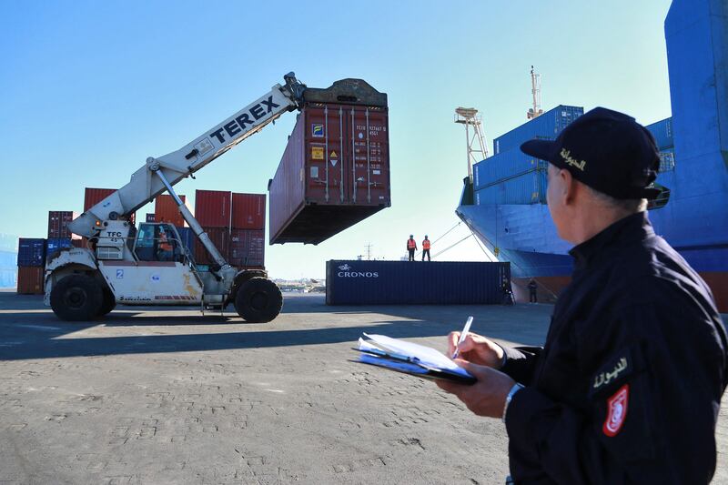 A Tunisian customs officer takes notes as containers filled with illegally imported Italian waste are shipped back.