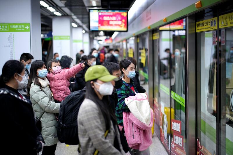 People wearing face masks wait for a subway train on the first day the city's subway services resumed following the novel coronavirus disease (COVID-19) outbreak, in Wuhan of Hubei province, the epicentre of China's coronavirus outbreak, March 28, 2020. The Chinese characters  REUTERS/Aly Song