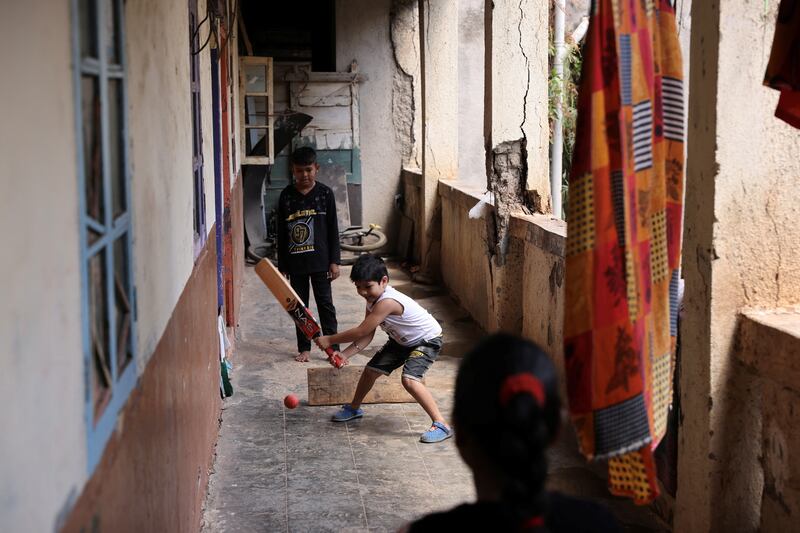 Balasaheb Khade's son and other children play cricket in the corridor