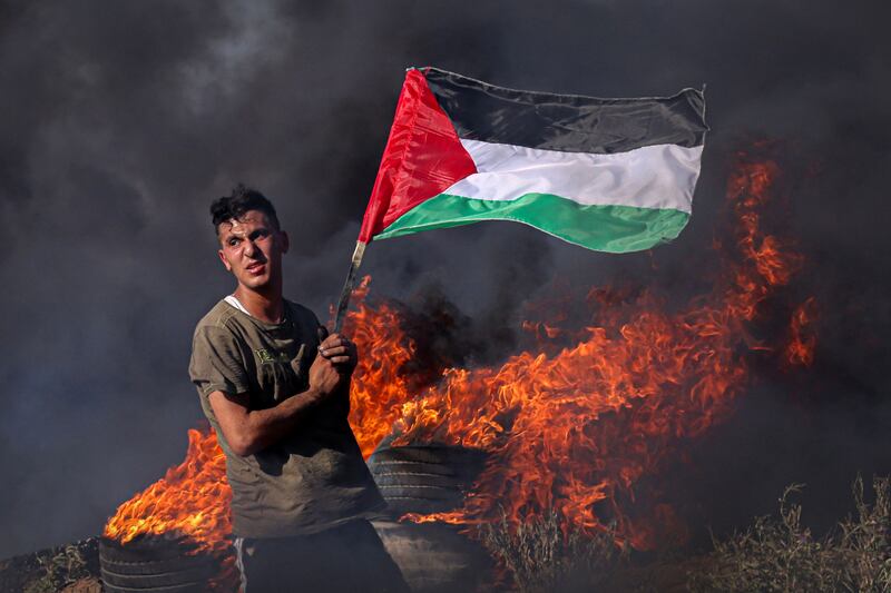 A Palestinian youth burns tyres during a protest by the border fence with Israel east of Gaza City on on July 3. AFP