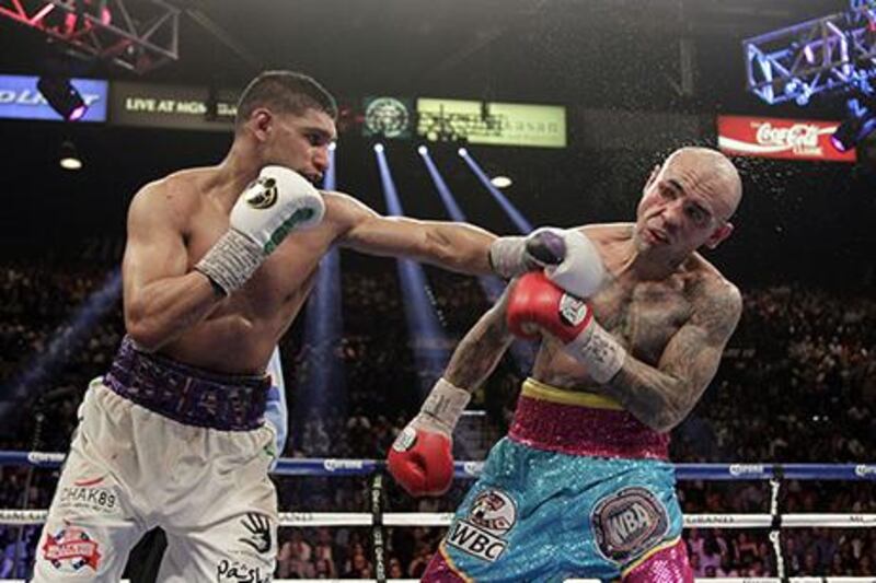 Amir Khan, left, was fighting for the first time after a yearlong layoff, but the British boxer knocked Luis Collazo down three times in the non-title fight. John Gurzinski / AFP