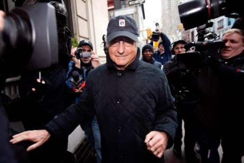 Financier Bernard Madoff (C) is surrounded by reporters as he arrives to his apartment building after being placed under house arrest by a judge in New York, New York, USA, 17 December 2008. Madoff was arrested last week and charged with allegedly running a 50 billion dollar 'Ponzi scheme'.  EPA/JUSTIN LANE