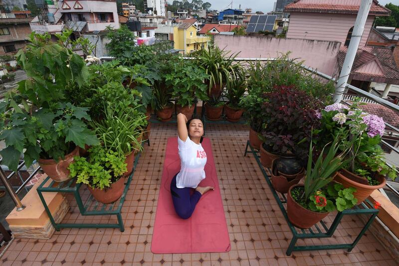 Yoga instructor Suzana Pradhan performs a yoga posture at the rooftop of her house in Kathmandu, Nepal. AFP