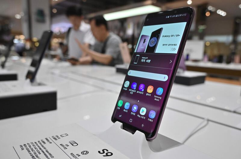Visitors look at Samsug Galaxy S9 smartphone at its showroom in Seoul on August 2, 2019. South Korean President Moon Jae-in on August 2 condemned Japan's decision to remove his country from a "white list" of favoured trading partners, calling it a "very reckless" move and threatening unspecified countermeasures. / AFP / Jung Yeon-je
