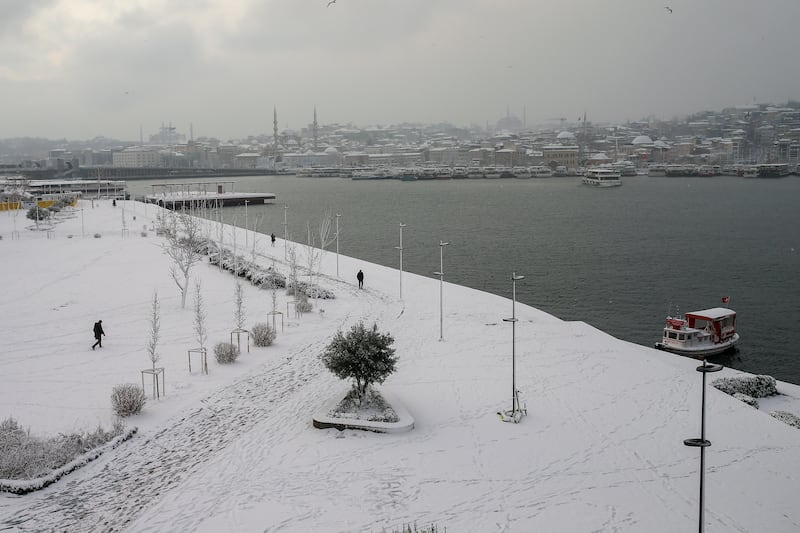 People walk in the snow beside the Golden Horn. AP