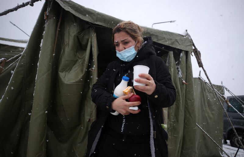 A woman walks out of a tent on the Belarusian side of the EU's eastern border. Reuters