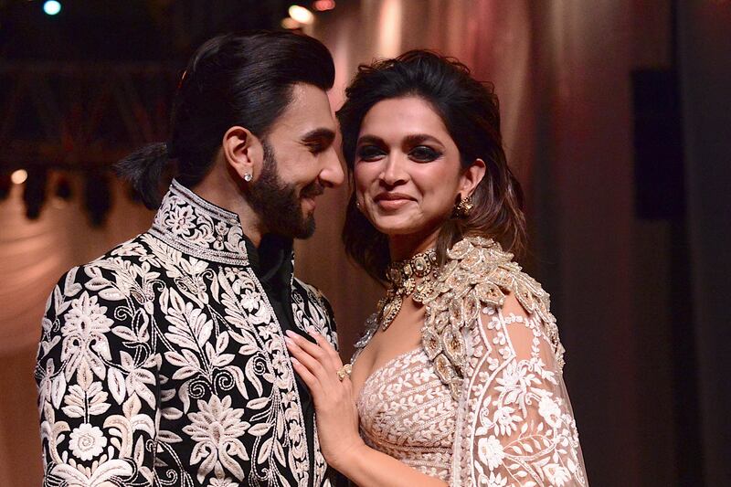 In this picture taken on July 29, 2022, Bollywood actors Ranveer Singh and Deepika Padukone walk the ramp for Mijwan Welfare Society and fashion show by designer Manish Malhotra in Mumbai.  (Photo by SUJIT JAISWAL  /  AFP)