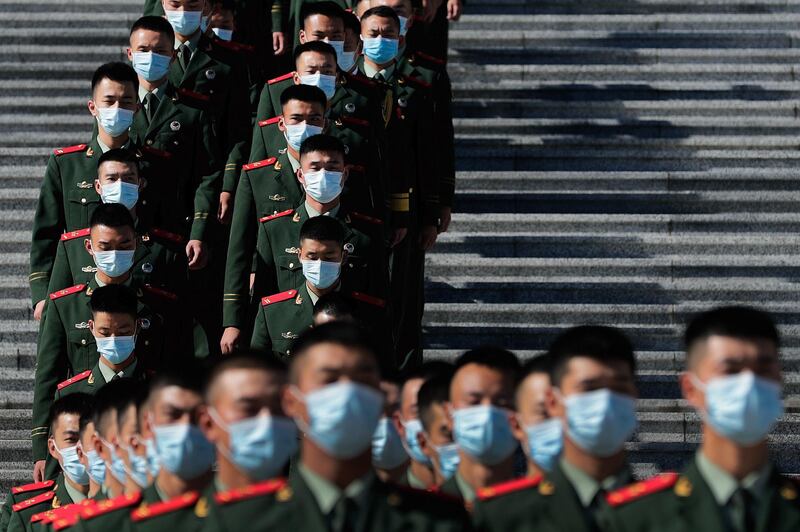 Chinese paramilitary policemen, wearing face masks to help curb the spread of the coronavirus, march down a staircase outside the Great Hall of the People after attending the commemorating conference on the 70th anniversary of China's entry into the 1950-53 Korean War, in Beijing. AP