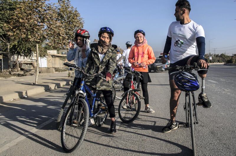 Rashidi, cycling on the right, with his prosthetic leg. 
Peace on Wheels hopes to promote young people's participation in the peace process. Activists took to their bikes on Friday morning, cycling about 20 kilometres through Kabul. 
"Young people’s voices aren’t heard in the peace process, but this needs to change," Rashidi said. 