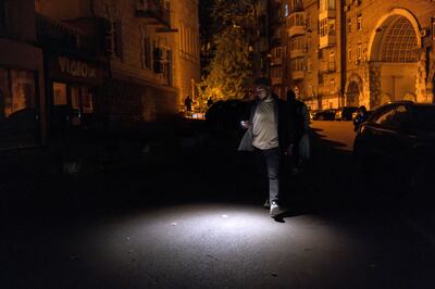 A man uses his phone torch during a partial power cut in Kyiv. Reuters 