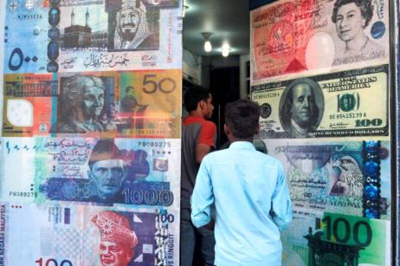Pakistani customers enter a foreign currency exchange shop in Karachi on October 14, 2010. The dollar fell against most Asian currencies while the region's stock markets posted strong gains on growing expectations of new pump-priming measures by the US.  AFP PHOTO / RIZWAN TABASSUM

 *** Local Caption ***  413892-01-08.jpg