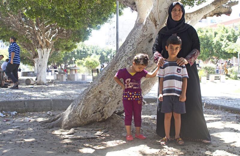 Fatima Syam, at the  Unknown Soldier park with her grandchildren, Rahaf, 3, and Ali, in Gaza City July 24,2014 .ÒThey need to get out,Ó said Mrs Syam, 47, referring to the nearby apartment that t other relatives have crammed into over the last week.More than 100,000 Gazans have been displaced by the fighting that erupted on July 8, according to the United Nations. More than 750 Palestinians have been killed and more than 4,000 wounded. (Photo by Heidi Levine for The National).