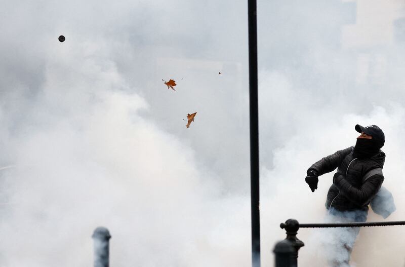 A protestor in Nantes, France throws a tear gas canister during a demonstration against a bill that would transform the country's current coronavirus health pass into a 'vaccine pass'. Reuters
