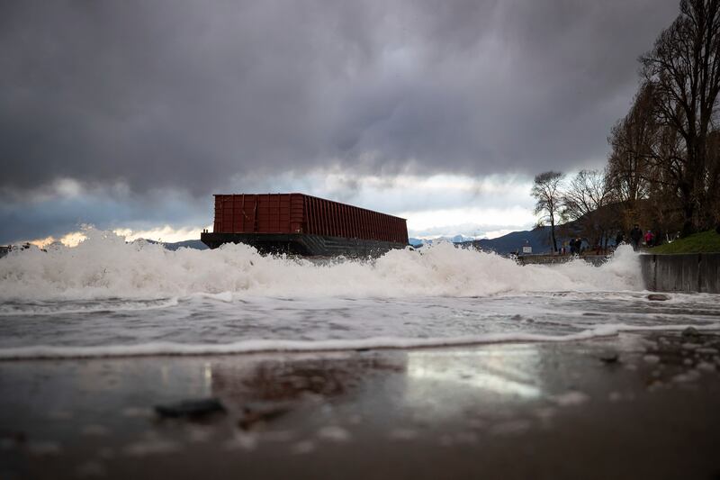 Waves crash as a barge that drifted loose on English Bay sits grounded on rocks during a windstorm, in the port city of Vancouver.