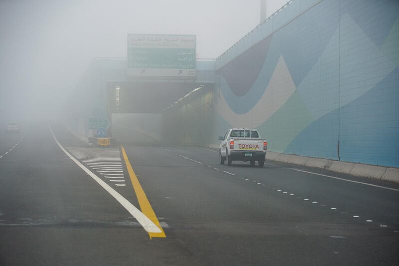 A vehicle drives to the Corniche in the morning fog. Victor Besa / The National