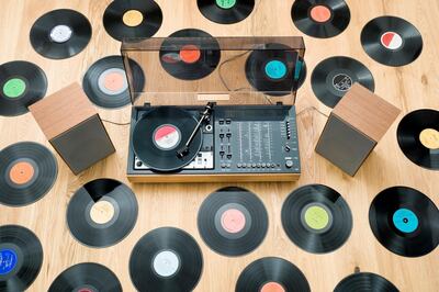 Records lying on floor surrounding 1970s stereo system. Getty Images