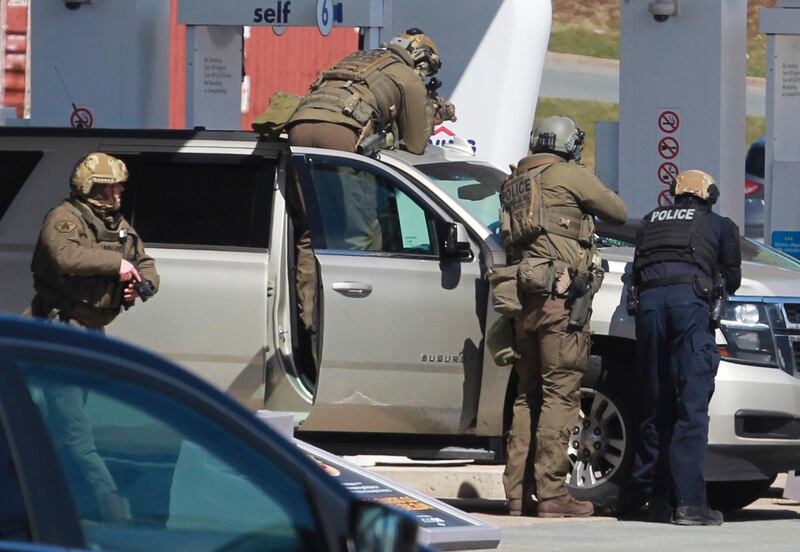 Royal Canadian Mounted Police officers surround a suspect at a gas station in Enfield, Nova Scotia.  AP