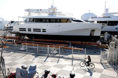 A cyclist rides past the 24-metre-long 'La Petite Ourse', belonging to Russian oligarch Alexei Kuzmichev, which is docked in the harbour of Antibes, south of France. AFP
