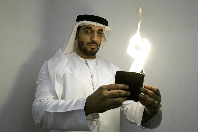 Moein Al Bastaki, an Emirati magician, performs an illusion in which he sets a wallet on flame. Jaime Puebla / The National