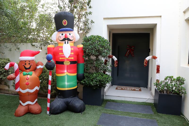 An inflatable nutcracker and gingerbread man welcome guests to Saadi's home