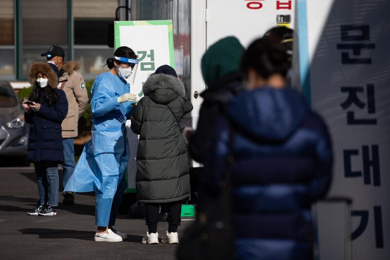 A medical worker talks to a person waiting in line at a temporary Covid-19 testing station in Seoul, South Korea. Bloomberg