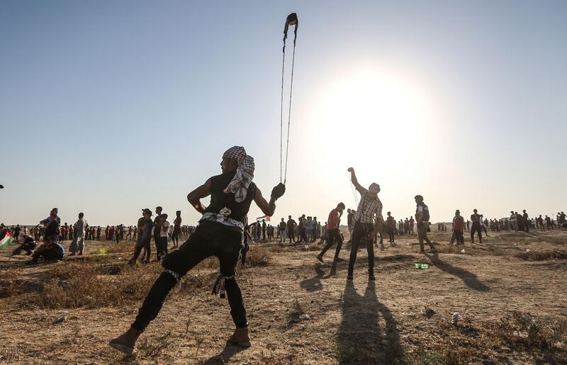 A Palestinian protester uses a slingshot to hurl stones during clashes with Israeli forces near the fence along the border with Israel in the eastern Gaza Strip.  AFP