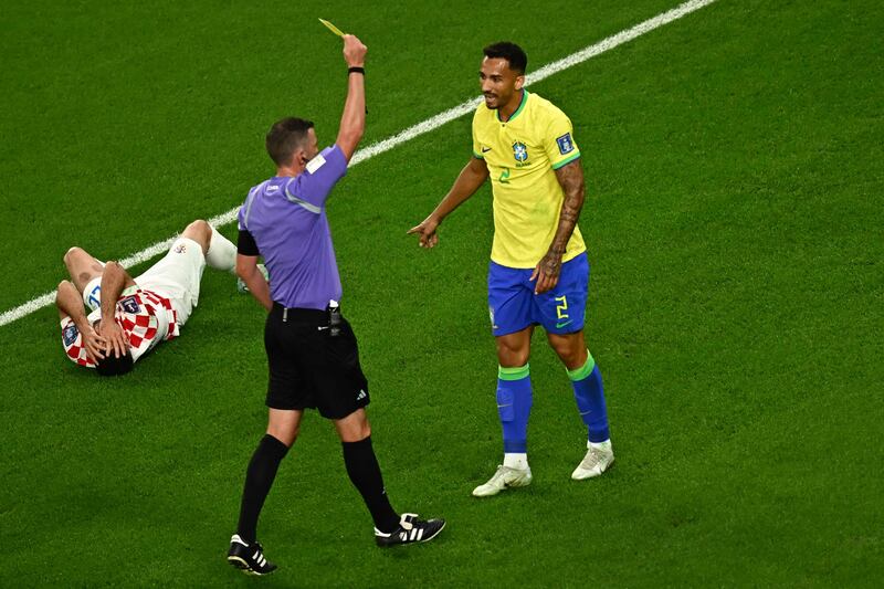 Referee Michael Oliver shows a yellow card to Brazil defender Danilo for his challenge on Josip Juranovic of Croatia. AFP