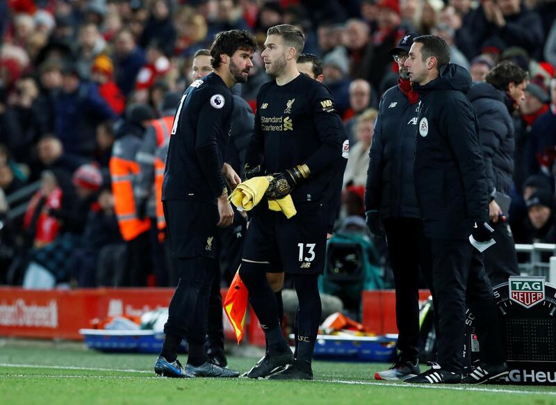 Liverpool's Alisson shakes hands with Adrian after being shown a red card by referee Martin Atkinson. Reuters