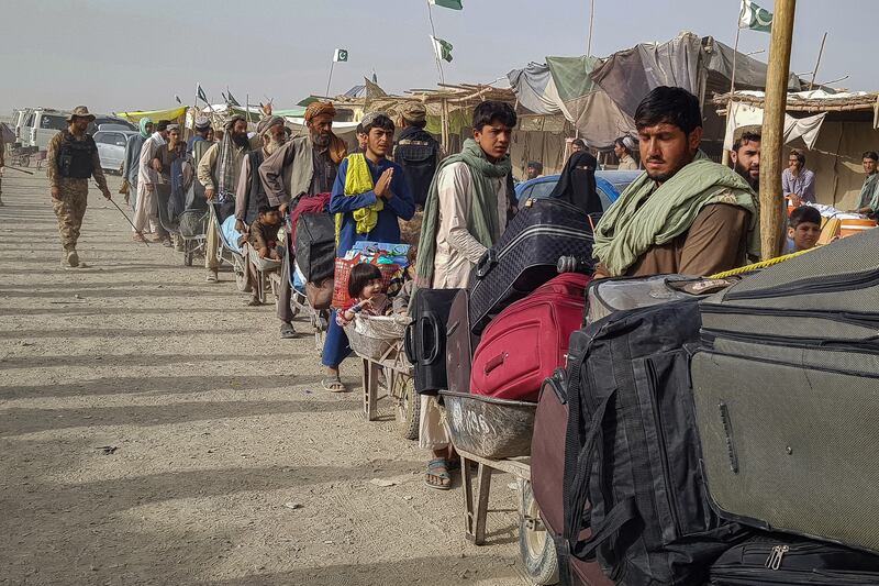 People queue at the Pakistan-Afghanistan border point in Chaman on August 17, 2021 to cross back to Afghanistan. AFP