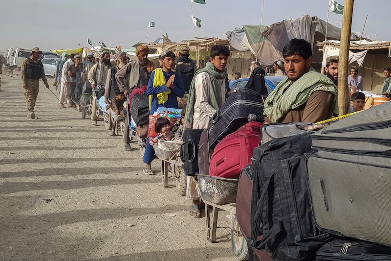 People queue at the Pakistan-Afghanistan border point in Chaman on August 17, 2021 to cross back to Afghanistan. AFP