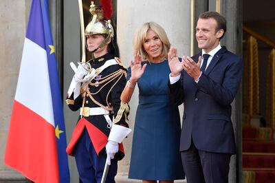 epa06893549 French President Emmanuel Macron and French First Lady Brigitte Macron wait for the France's national soccer team players at the Elysee Palace, in Paris, 16 July 2018. France won 4-2 the FIFA World Cup 2018 final against Croatia in Moscow, on 15 July.  EPA/JULIEN DE ROSA